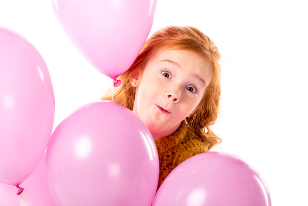 mueca de pelo rojo niño de pie con manojo de globos de color rosa aislado en blanco
 - Foto, Imagen