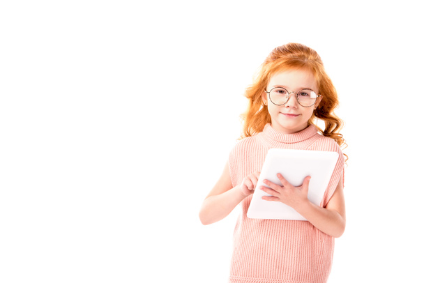  red hair kid holding tablet and looking at camera isolated on white - 写真・画像