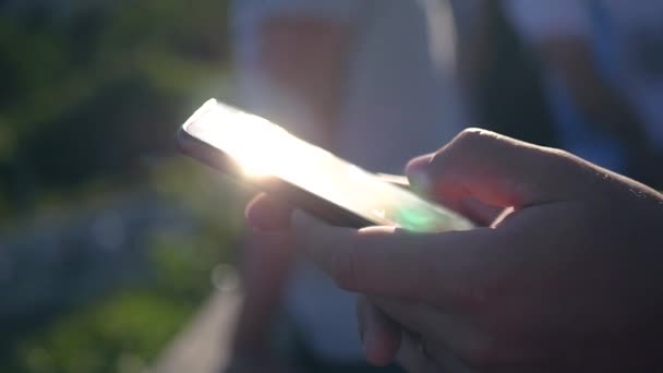 The phone is in the hands of a man who catches the rays of the sun and flashes into the camera. HD, 1920x1080. slow motion. - Filmmaterial, Video