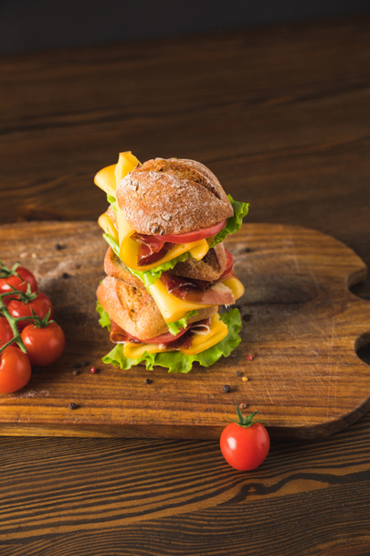 vista aérea de sándwich de queso grande con tomates cherry y vaso de cola en tablero de madera
 - Foto, Imagen