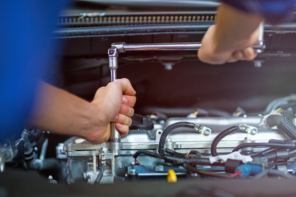 Mechanic working on engine in auto repair shop - Photo, Image