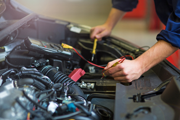 Mechanic working on engine in auto repair shop - Foto, Imagen