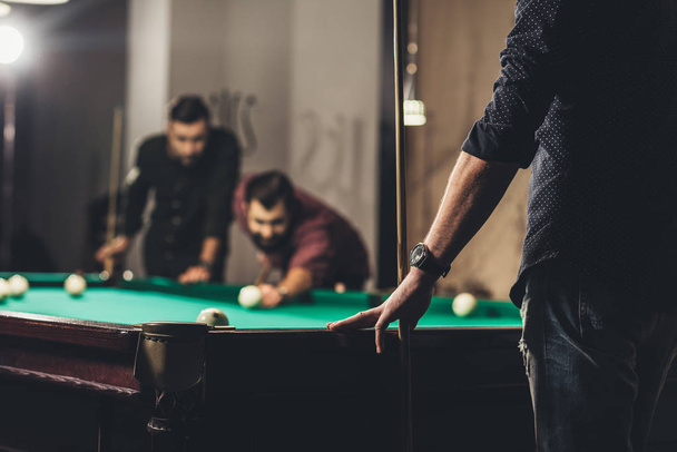 cropped image of successful handsome men playing in pool at bar - Foto, afbeelding