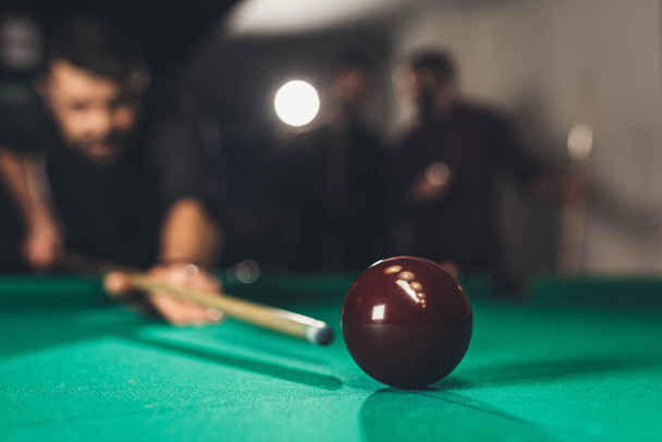 young successful handsome man playing in russian pool at bar with friends - Foto, immagini