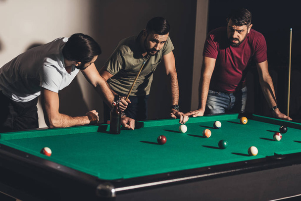 three handsome caucasian men playing in billiard at bar - Foto, immagini
