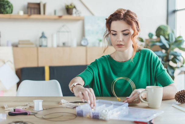 mujer joven haciendo collares en taller hecho a mano
 - Foto, Imagen