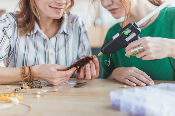 cropped shot of women making accessory with glue gun - Photo, Image