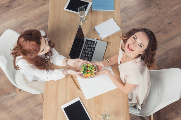 top view of coworkers holding bowl healthy salad at office - Фото, изображение