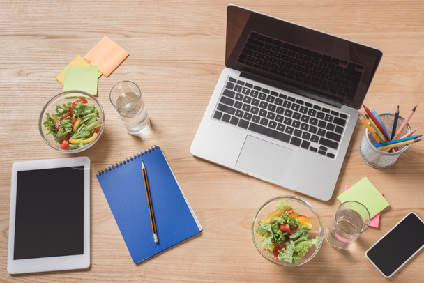 top view of workplace with digital devices and healthy salad - Photo, Image