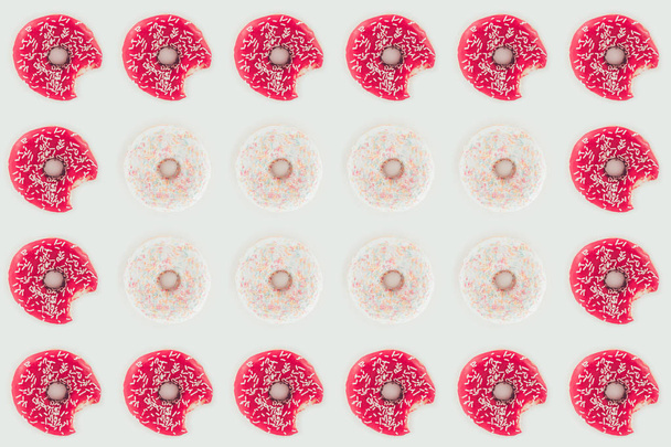 top view of seamless pattern of bitten pink and white doughnuts isolated on white - Photo, Image