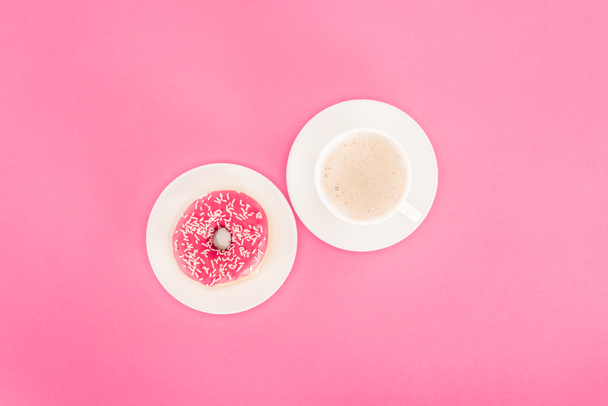 bovenaanzicht van donut met kop koffie geïsoleerd op roze - Foto, afbeelding