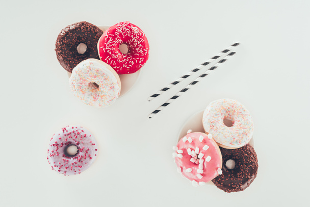 Top bekijken van smakelijke verschillende donuts op witte ondergrond - Foto, afbeelding