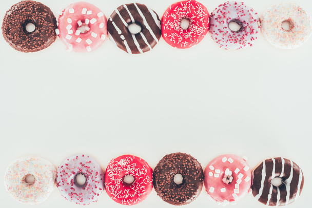 вид сверху рамы из различных пончиков с глазурью
 - Фото, изображение