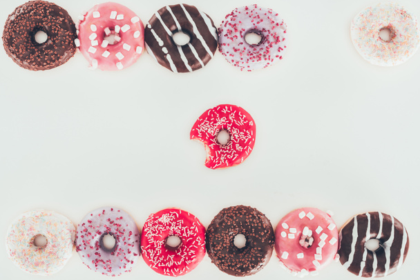 bovenaanzicht van verschillende geglazuurde donuts geïsoleerd op wit - Foto, afbeelding