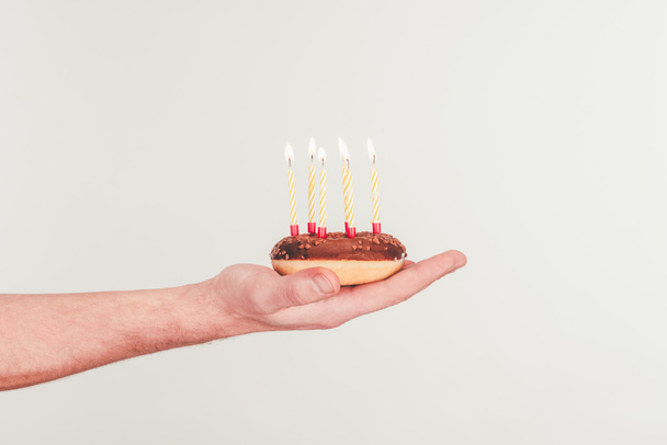 tiro recortado de mujer sosteniendo donut con vela de cumpleaños
 - Foto, Imagen
