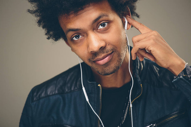 Happy african man smiling listening to music in headphones. White background. - Fotó, kép