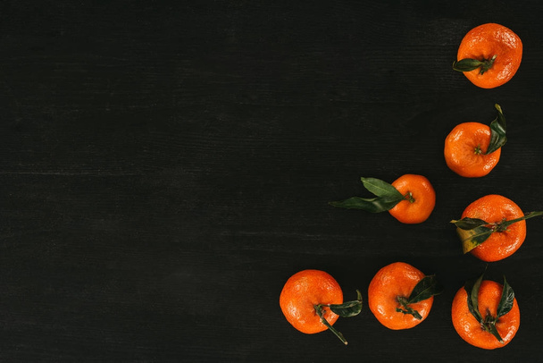 top view of ripe tangerines on black wooden surface - Fotoğraf, Görsel