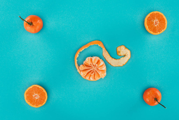 tendido plano con mandarinas maduras y piezas anaranjadas aisladas en azul
 - Foto, imagen