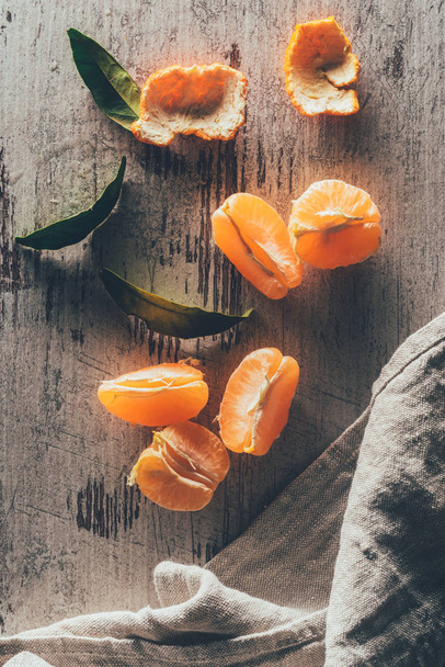 tendido plano con mandarinas y lino en la superficie de madera de mala calidad
 - Foto, Imagen