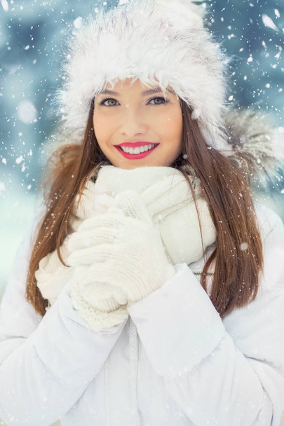 Piękny uśmiechający się młoda kobieta w ciepłą odzież. Pojęcie portret w zaśnieżonej zimy - Zdjęcie, obraz