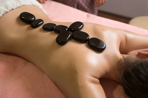 Massage aux pierres Spa. Belle femme obtenir spa pierres chaudes massage dans le salon de spa. - Photo, image