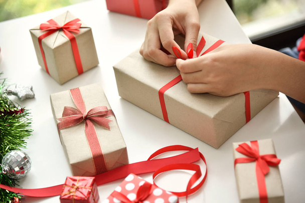 Female hands wrapping  present boxes. - Φωτογραφία, εικόνα