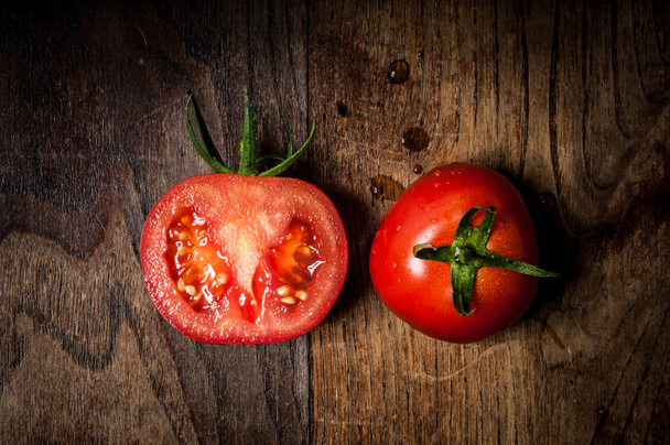 metade e tomates inteiros em madeira
 - Foto, Imagem