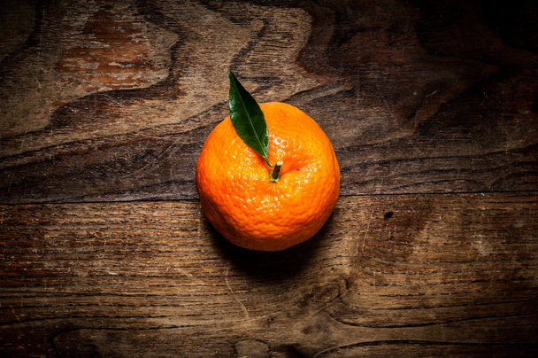 Mandarine mit Blatt auf Holz - Foto, Bild
