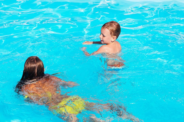 Niños jugando y divirtiéndose en la piscina con aire
 - Foto, imagen