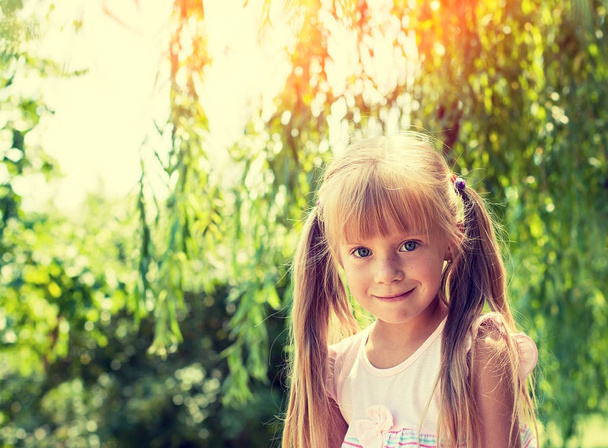 Portrait of smiling little girl in the park in summer - Foto, Imagem