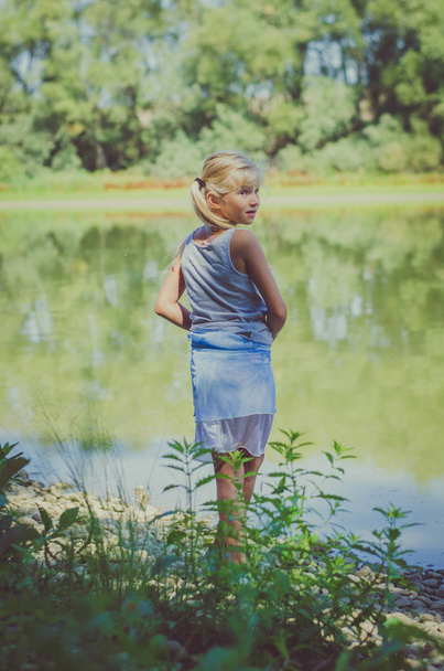 little child  by the river looking back - 写真・画像