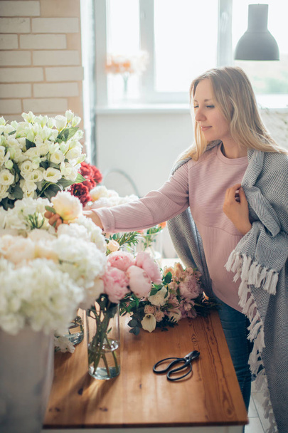 Florist workplace: woman arranging a bouquet with flowers - Photo, Image