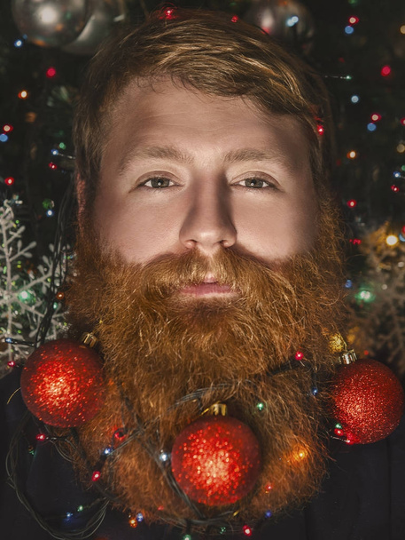 Un homme barbu avec une barbe décorée pour les vacances de Noël. Décoration de Noël
. - Photo, image