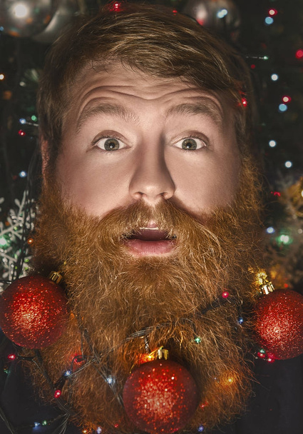A bearded man with a decorated beard for the Christmas holiday. Christmas decoration. - Zdjęcie, obraz