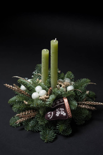 close-up of green fir tree branches with Christmas decoration and candles on black background - Photo, Image
