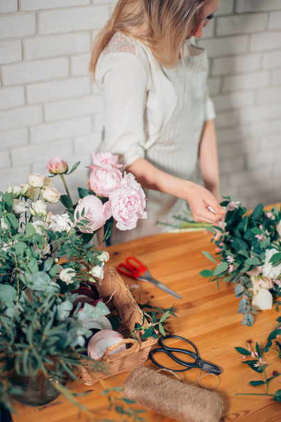 pretty young woman making fashion modern bouquet of different flowers. - Фото, зображення
