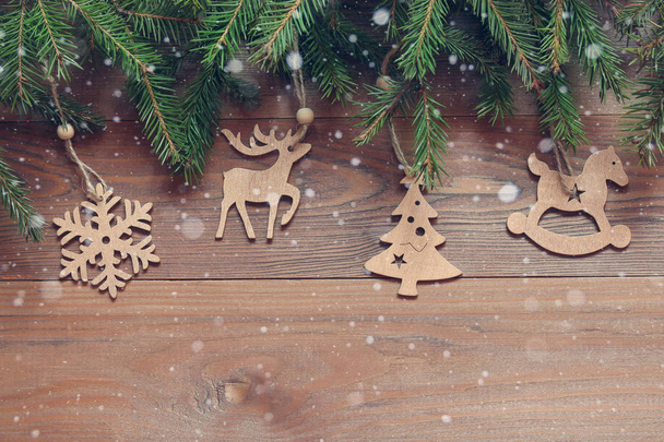 Christmas background. Wooden figures on the fir branches - Фото, изображение