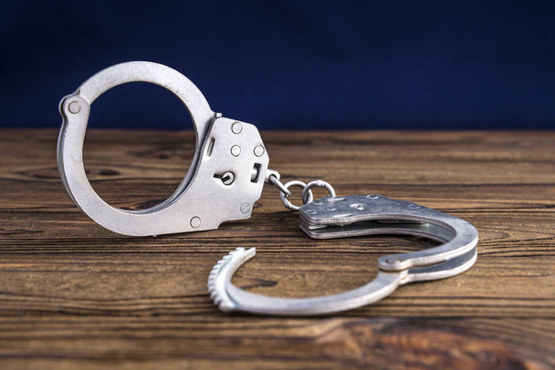 handcuffs on wooden background - Фото, изображение