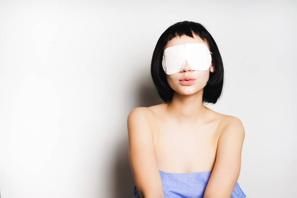 young beautiful girl with black hair looks after herself, in front of her white mask - Foto, immagini
