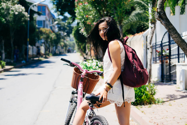 Happy smiling girl in tropical city,riding on vintage bike,hot summer - Photo, Image