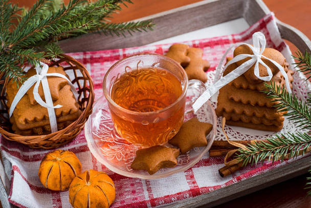 Traditional Christmas tea, gingerbread with a cup of hot tea, a large set of cookies on a tray on a wooden table - Photo, image