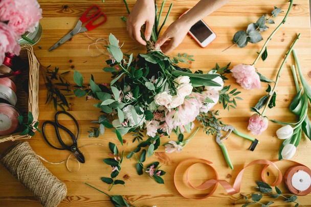 Top view of florist hands arranging and decorating flowers. - Foto, afbeelding