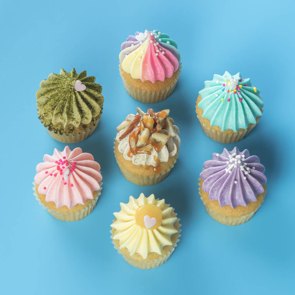 schicke Mini-Cupcakes von oben auf blauem Hintergrund - Foto, Bild