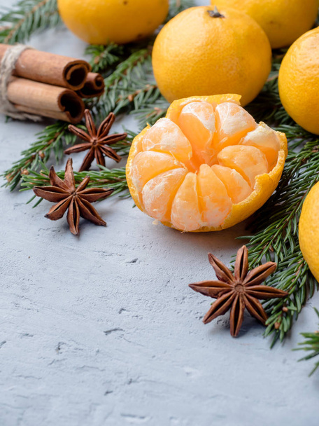 Fresh tangerines with branches of Christmas tree, star anise cinnamon on gray concrete background Copy space - Photo, Image