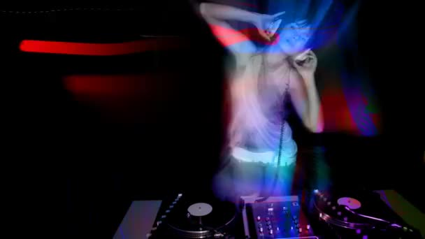mooie jonge vrouwelijke dj, achter de dekken bij een club - Video