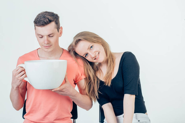 Young attractive couple on date in coffee shop with big coffee cup - Foto, Bild