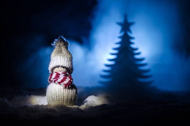Happy Santa Claus Doll op Kersttijd met boom en sneeuw. Kleurrijke bokeh achtergrond. Kerstman en Merry Christmas model figuur speelgoed op donker getinte - Foto, afbeelding