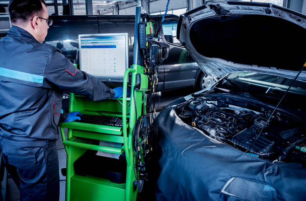Meccanico di auto professionale che lavora nel servizio di riparazione auto. Diagnostica del computer motore
 - Foto, immagini