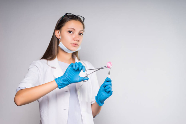 serious young girl doctor dentist holding dental tools in hands - Фото, зображення