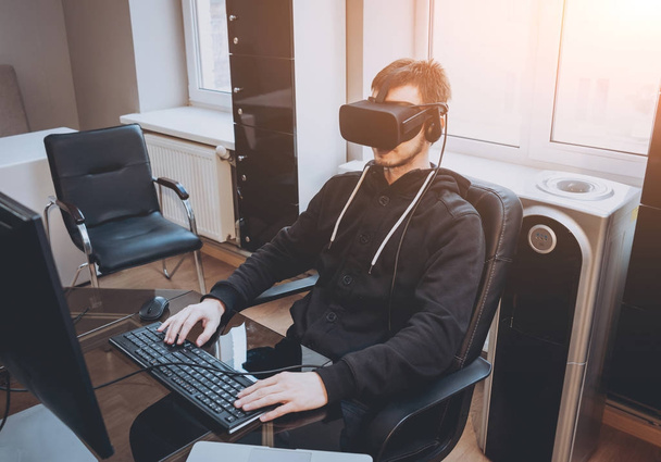 Young man in virtual reality headset in office - 写真・画像